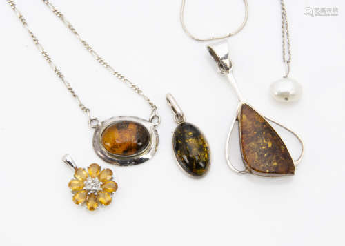 Two silver amber set pendants, another citrine flower head silver set pendant, amber necklace, a