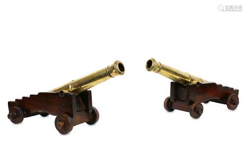 A GOOD PAIR OF 19TH CENTURY BRONZE MODELS OF CANNONS with tapering bronze barrels and raised on