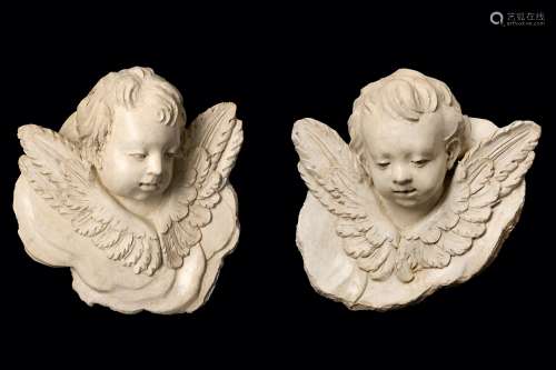 A PAIR OF VENETIAN MARMORINO PLASTER HEADS OF PUTTI, PROBABLY 18TH CENTURY the winged putti with