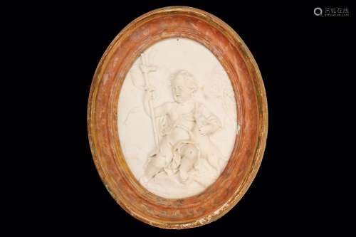 AN 18TH CENTURY ITALIAN CARVED MARBLE RELIEF OF SAINT JOHN THE BAPTIST of oval form, the infant St