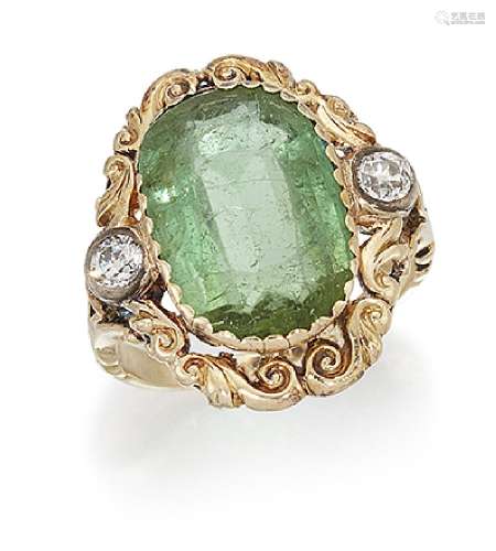 A late 19th century tourmaline and diamond ring, the cushion shaped green tourmaline within a scroll