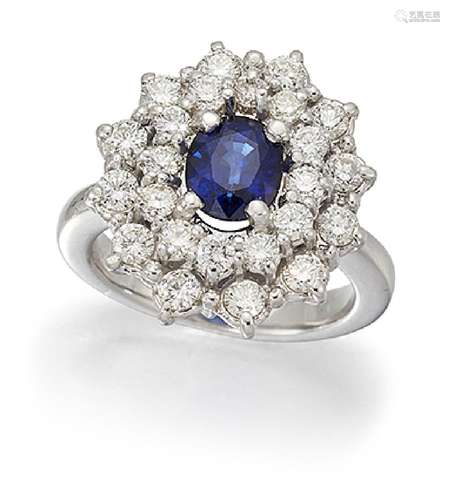 A sapphire and diamond cluster ring, the oval sapphire in claw mount to a brilliant-cut diamond