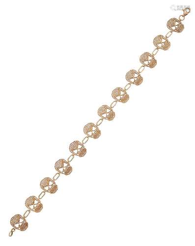 A diamond bracelet, composed of a line of twelve brilliant-cut diamond openwork skulls with single