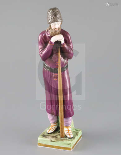 A Russian Gardner porcelain figure of a man holding a staff, mid 19th century, wearing traditional