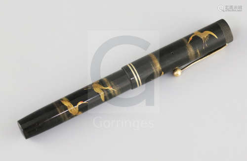 A Dunhill Namiki black lacquered fountain pen, decorated with cranes flying amongst clouds,