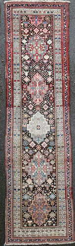 A Persian ivory ground runner, with filed of hooked geometric motifs and multi row border, 13ft