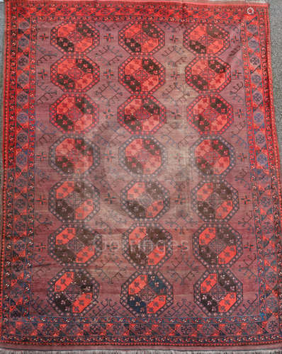 An Afghan aubergine and red ground carpet, with field of octagons and geometric motifs, 11ft 6in