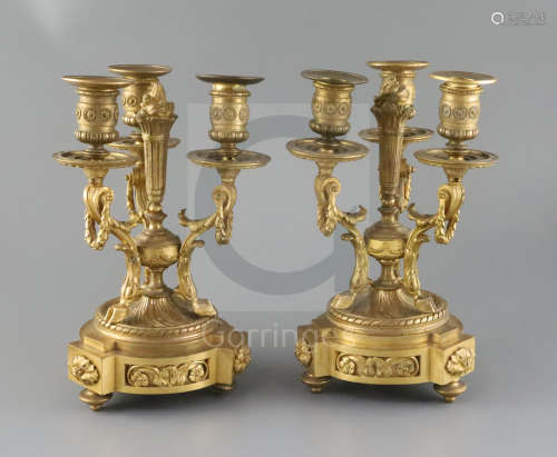 A pair of Louis XVI style ormolu candelabra, with central torch stems, triple foliate scrolled