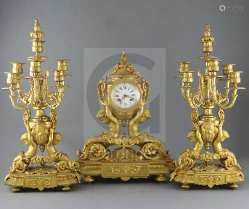 A 19th century French ormolu clock garniture, modelled with putti supporting urns, floral swags