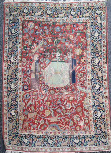 A Caucasian red ground rug, with three figures(one kneeling) in a field of scrolling foliage with