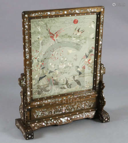 A Chinese embroidered silk, hongmu and mother of pearl framed table screen, c.1900, the