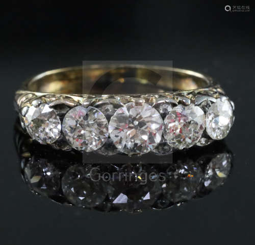 A Victorian style gold and graduated five stone diamond half hoop ring, with carved setting, the
