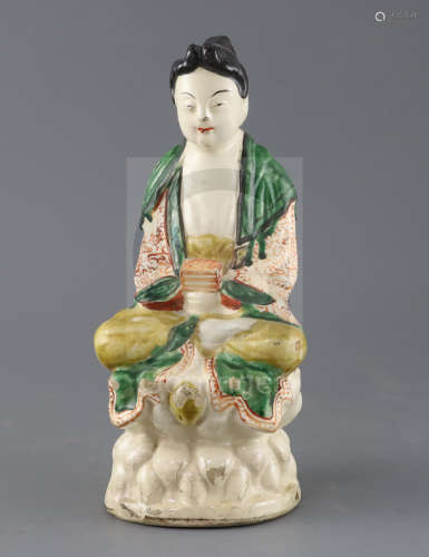 A Chinese Sancai glazed pottery seated figure of Guanyin, Qing dynasty, with scrollwork decoration