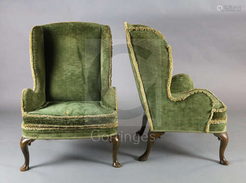 A pair of 19th century George I style mahogany wing armchairs, with scroll carved cabriole legs on