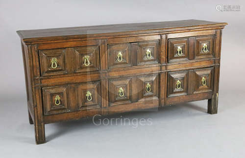 A 17th century style oak dresser base, fitted six geometric moulded drawers with drop handles, on