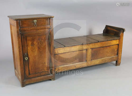 An early 19th century French oak box seat settle, with frieze drawer and cupboard flanking a box