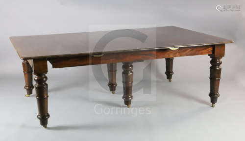 An early Victorian mahogany extending dining table, with rounded rectangular top, six spare