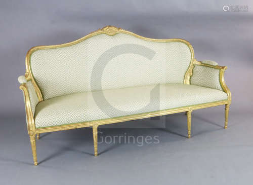 A Louis XVI style giltwood settee, with scroll, harebell and paterae carved frame, on turned tapered
