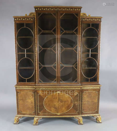 An early 20th century parcel gilt walnut breakfront bookcase, with paterae decorated frieze and four