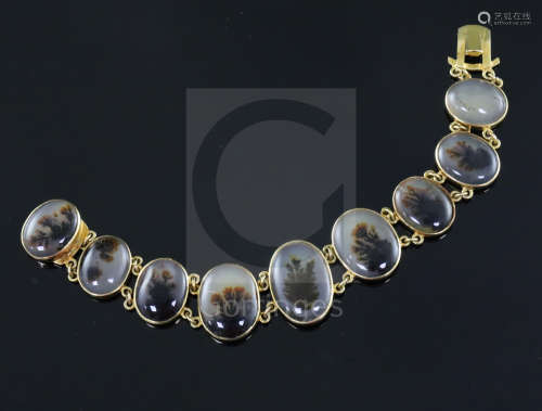 A late Victorian gold and moss agate bracelet, set with nine graduated oval agates, approximately