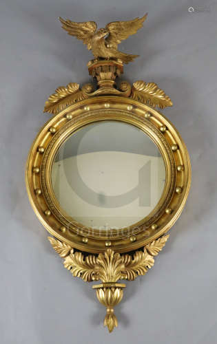 A William IV giltwood and gesso convex wall mirror, with eagle surmount, W.1ft 10in. H.3ft 5in.