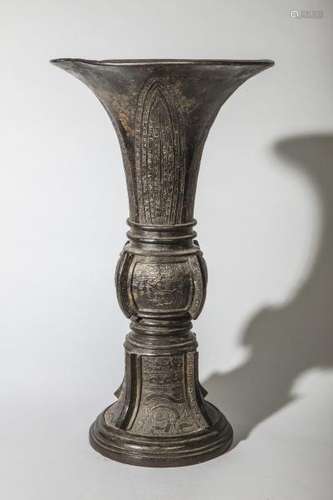 Vase de forme Gu moulé de motifs archaïsants et d'arrêtes saillantes. Bronze. [...]