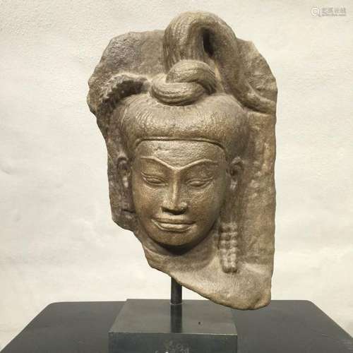 Haut relief de temple sculpté d'une tête de Shiva coiffé d'un chignon noué [...]