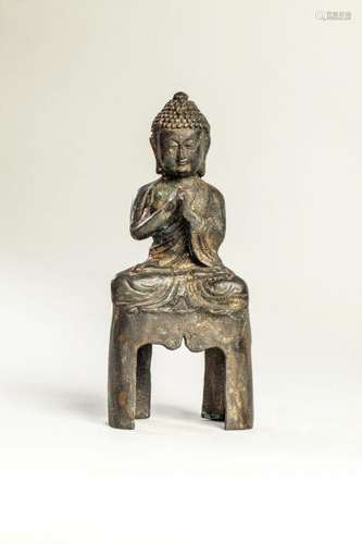 Buddha vêtu d'une robe monastique assis en méditation sur un haut socle [...]