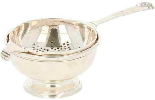 Silver tea strainer with stand.