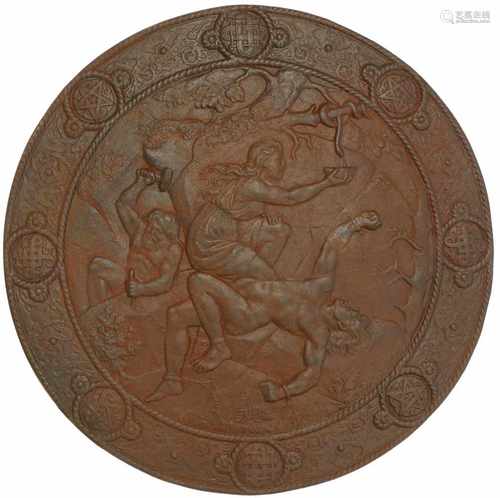 A cast iron shield with depictions of Norwegian mythology, Loki and Sigyn.