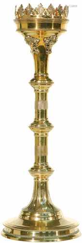 A bronze church candlestick holder decorated in an eclectic style.