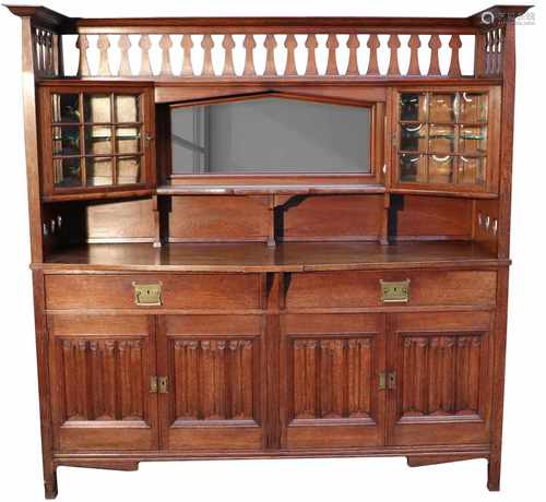 An Art Nouveau oakwood sideboard with glass- and carved linenfold panels. Circa 1910.