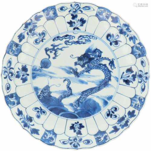 A porcelain plate, decorated with dragons and carps, scalloped rim, marked with 'good luck'-