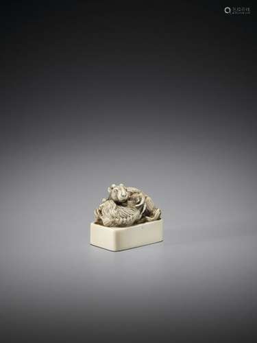 A FINE IVORY SEAL NETSUKE OF TWO EMBRACING GOATS U…