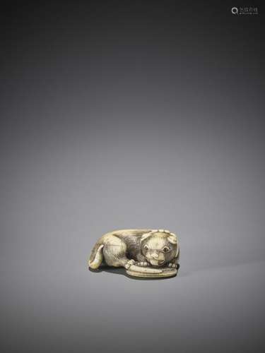 AN OSAKA SCHOOL IVORY NETSUKE OF A DOG WITH SANDAL…