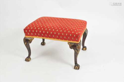 An 18th century overstuffed stool, the cabriole legs with anthemion carved knees and claw and ball