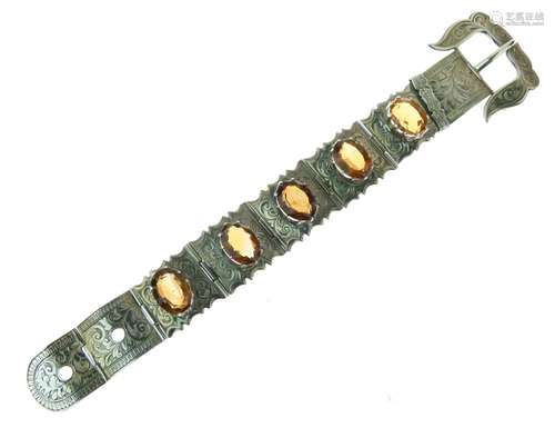 Victorian citrine set buckle bracelet, the five oval cuts set to engraved panels, unmarked, 18cm