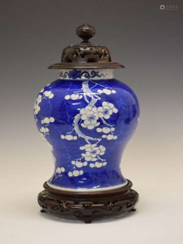Chinese porcelain blue and white prunus jar and cover, the turned pierced domed wooden cover over