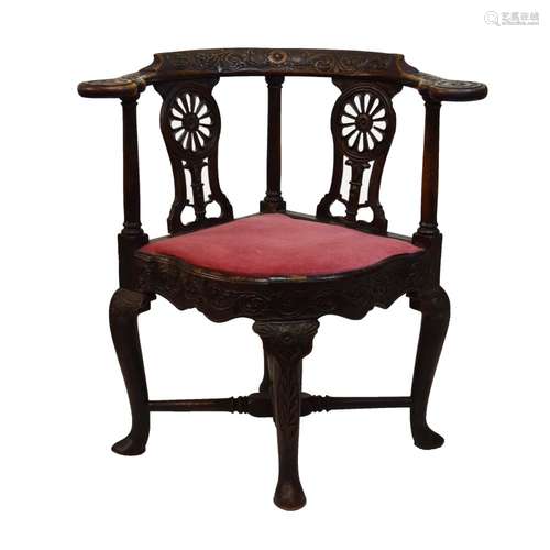 18th Century walnut 'smoker's bow' corner armchair, later carved, the curved top rail with flower