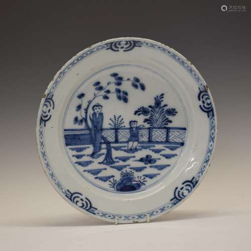 18th Century English Delftware plate, the circular field decorated with two Chinoiserie figures in a