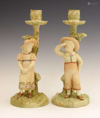 Pair of late Victorian Royal Worcester porcelain figural candlesticks modelled by James Hadley, as a