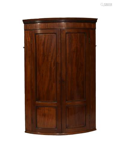 Early 19th Century inlaid mahogany bowfront corner cupboard, the moulded dentil cornice over