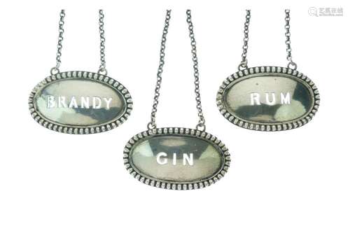 Three Victorian spirit labels, of bead-edged oval form pierced for Brandy, Rum and Gin, London 1863,