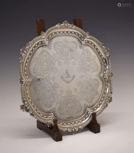 Edward VII silver salver, with bead and shaped border standing on three ball and claw feet with