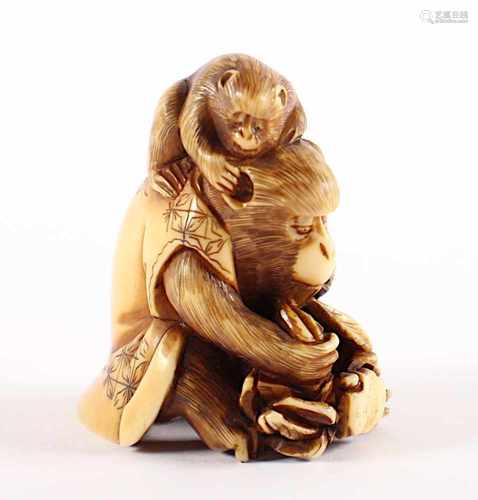 NETSUKE AFFEN MIT KRABBE, Elfenbein, ein großer, sitzender Affe mit einer Jacke hält mit allen