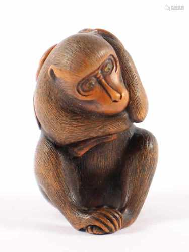 NETSUKE AFFE MIT KAKIZWEIG, Buchsbaum, Augen Horn, der sitzende Affe hält mit beiden Händen einen