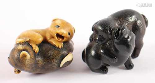 ZWEI NETSUKE HUNDE, a) schwarzes Holz, Augen schwarzes Horn, zwei spielende junge Hunde, L 4, b)