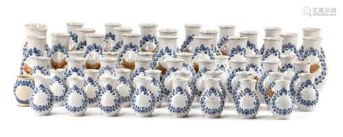 Collection of 55 pharmacy vessels. Nuremberg, mid-18th century. H. 13/16/21 cm. Baluster shaped vases in 3 sizes. Faience, white glazed, leaf wreaths in blue glaze colour. Partial remains of inscriptions in cold painting and glue. On the ground planet mark 
