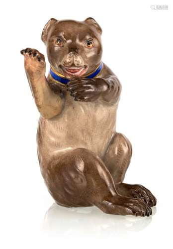 Brown bear. Meissen, probably in the middle of the 19th century. H. 9.5 cm. Sitting brown bear. Model by Johann Joachim Kändler. Naturalistically decorated with blue collar and gold border. Blue sword brand. Rest.