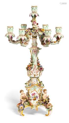 Ostentatious girandole. Meissen, circa 1870/80. H. 65 cm. Model by Leuteritz. Seven-flame. Flowering twigs and foliage, at the base three plastic putti with fruits and flowers. Underglazed blue sword mark, incised 